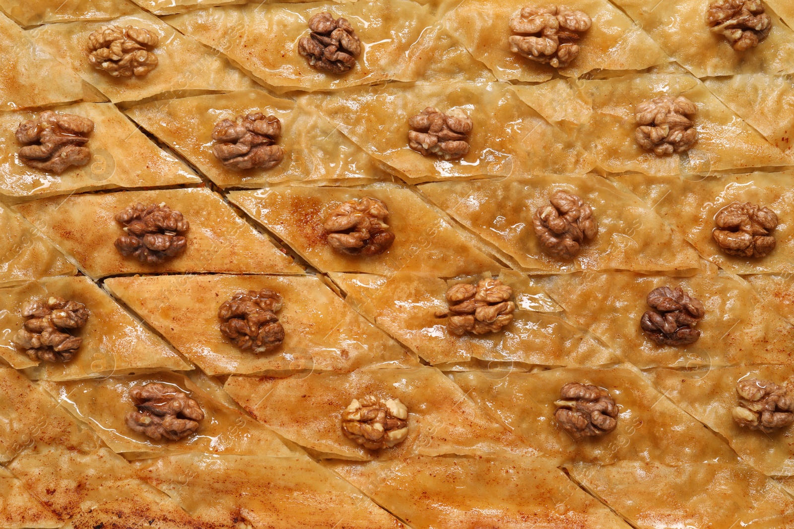 Photo of Delicious baklava with walnuts as background, top view