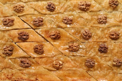 Delicious baklava with walnuts as background, top view