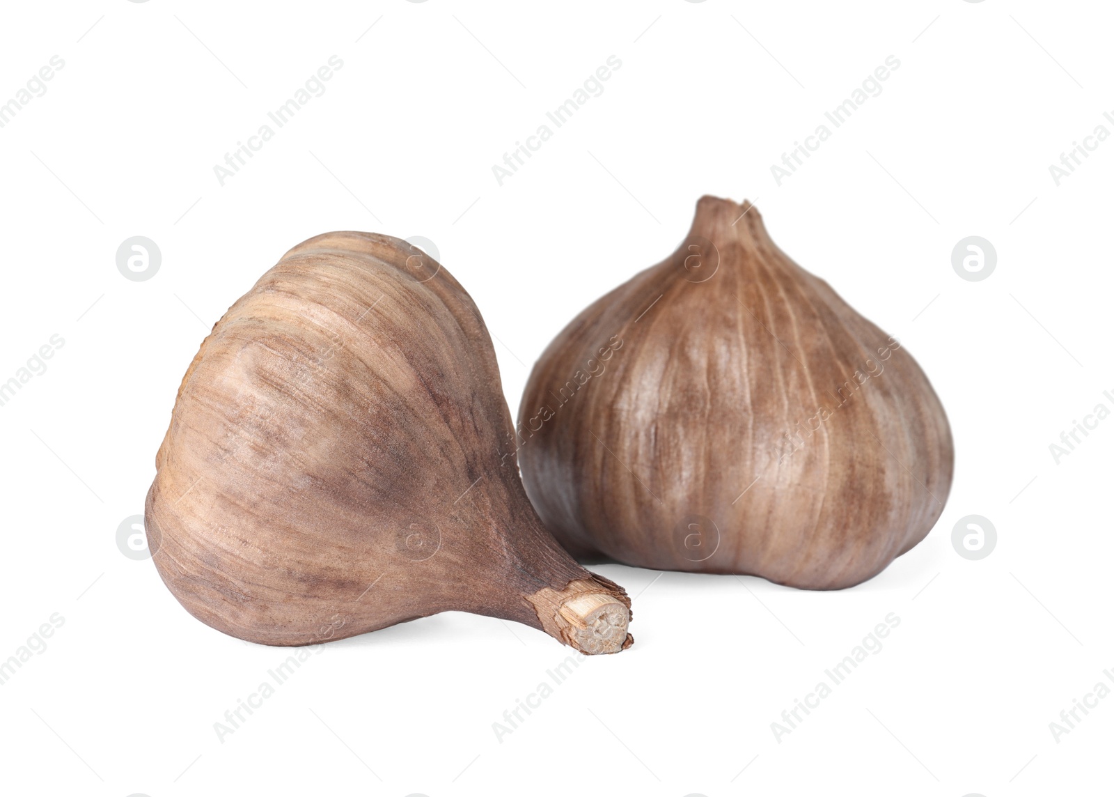 Photo of Unpeeled bulbs of black garlic on white background
