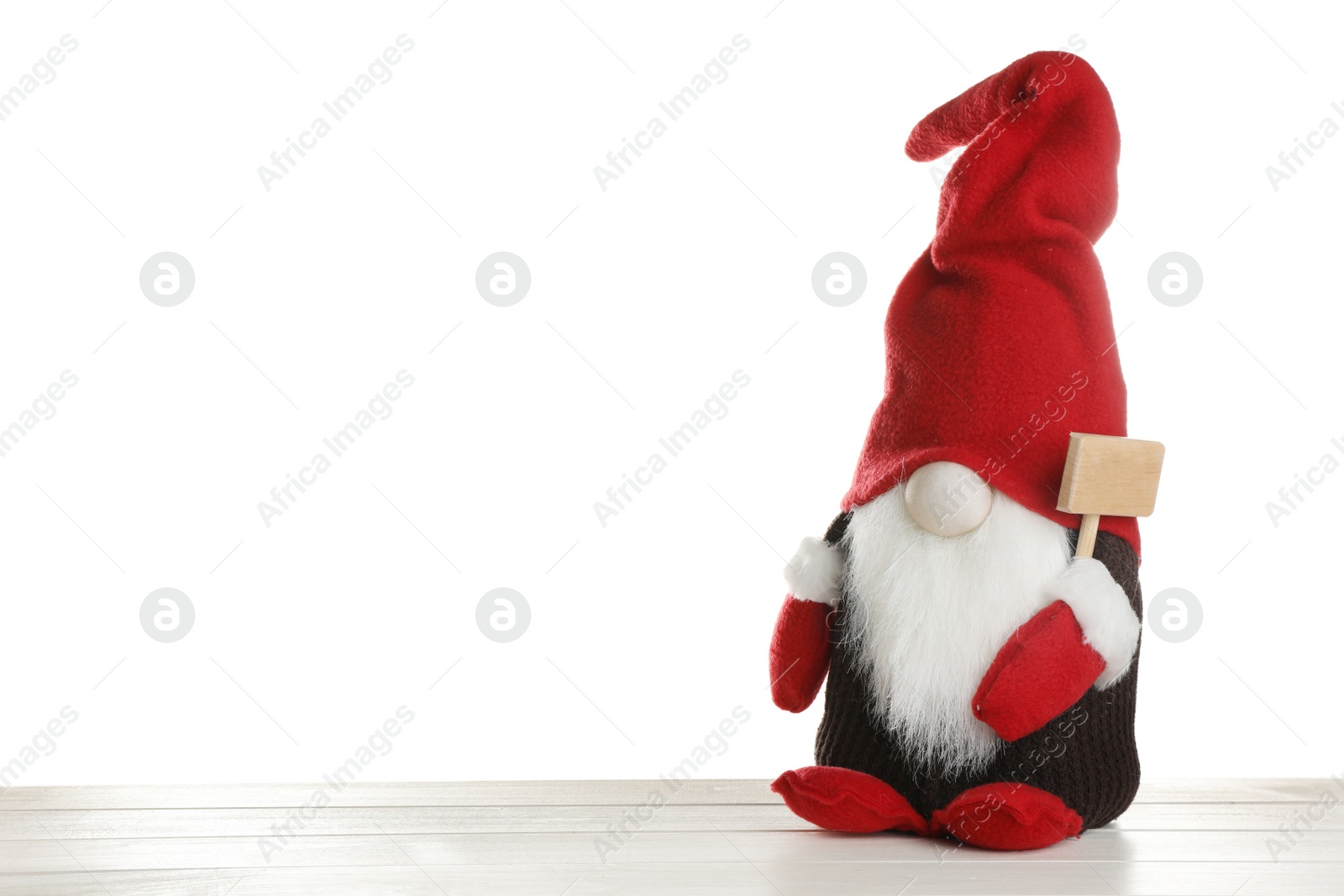 Photo of Funny Christmas gnome on wooden table against white background. Space for text