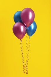 Photo of Bunch of bright balloons on color background