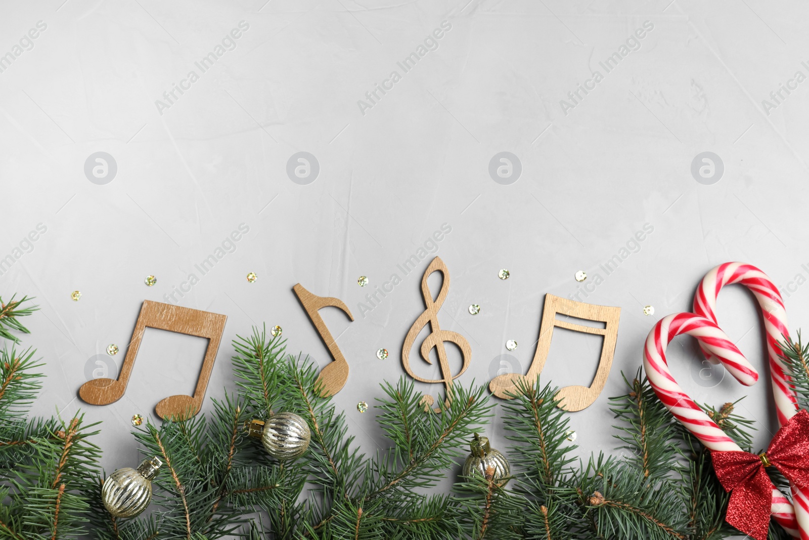 Photo of Flat lay composition with music notes on light grey background, space for text. Christmas celebration