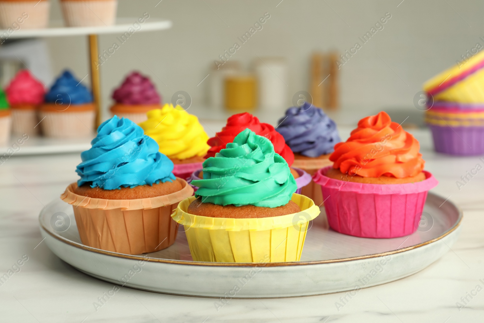 Photo of Delicious cupcakes with colorful cream on white table