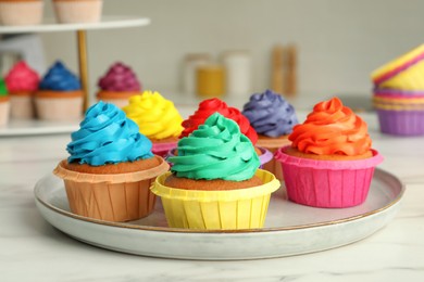 Delicious cupcakes with colorful cream on white table