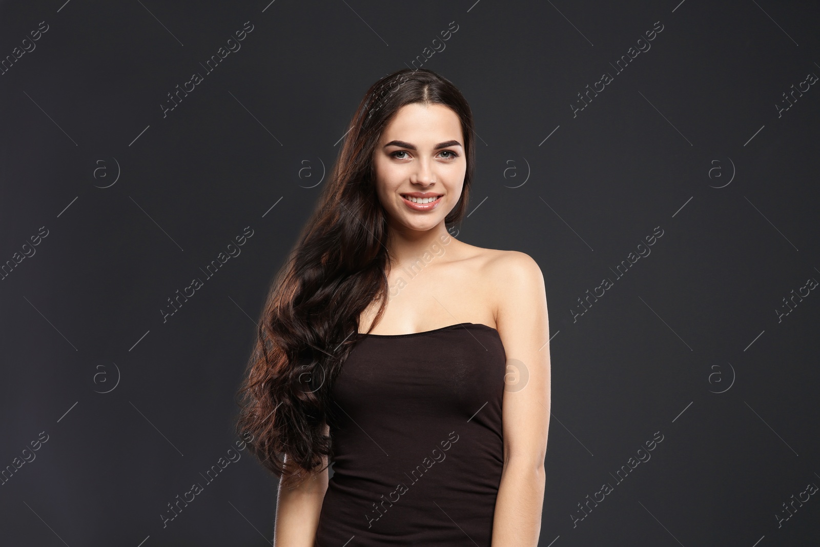 Photo of Portrait of beautiful model with gorgeous curly hair on black background