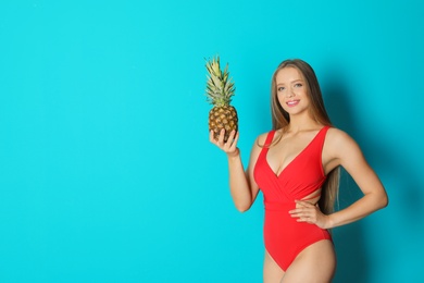 Beautiful woman with pineapple wearing bikini on color background