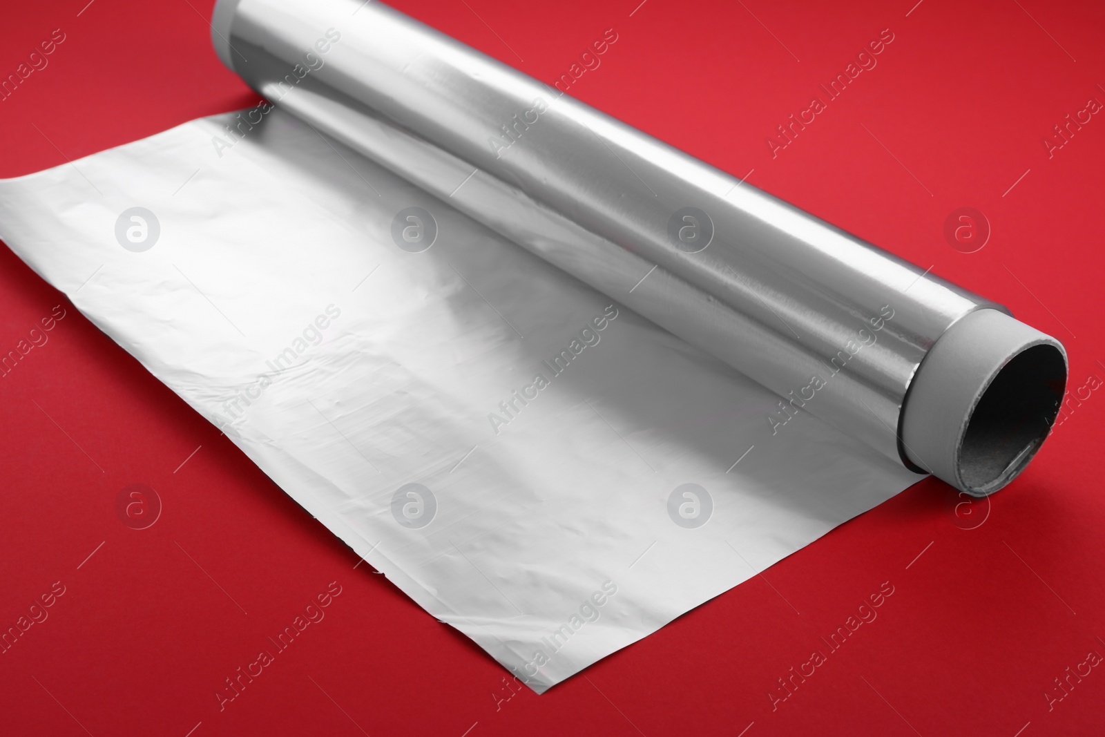 Photo of One roll of aluminum foil on red background