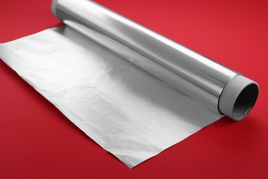 One roll of aluminum foil on red background