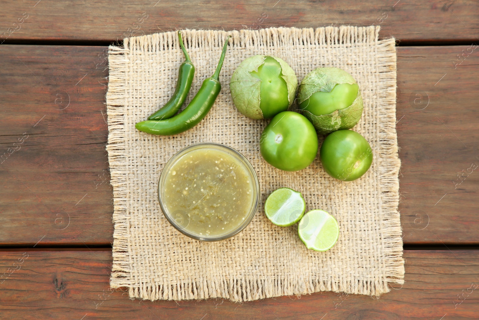 Photo of Tasty salsa sauce and ingredients on wooden table, top view