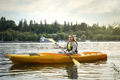 Photo of Beautiful young woman kayaking in river. Summer activity