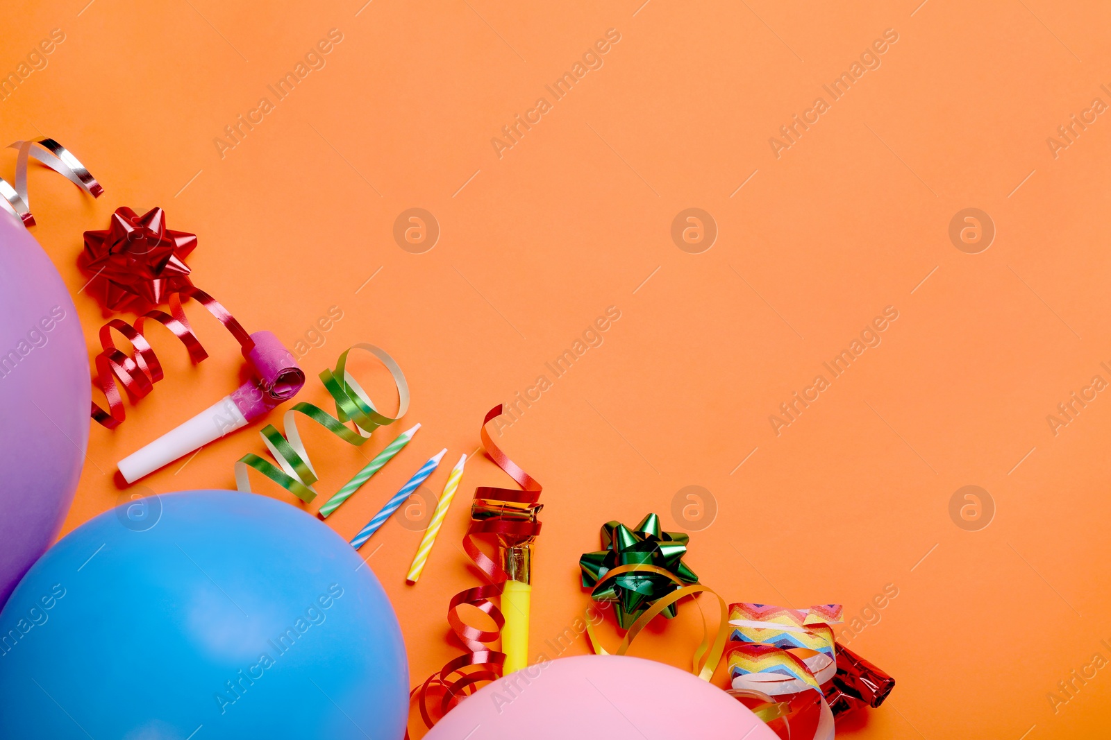 Photo of Flat lay composition with accessories for birthday party on orange background. Space for text