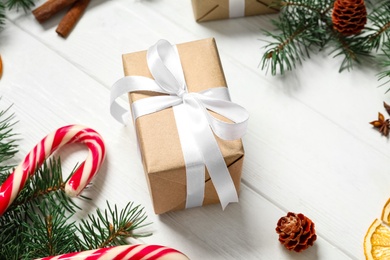 Photo of Christmas composition with gift box and festive decor on white wooden table