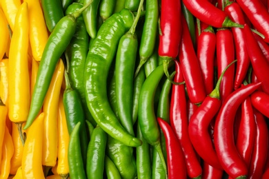 Ripe hot chili peppers as background, closeup