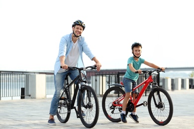 Dad and son riding bicycles together outdoors