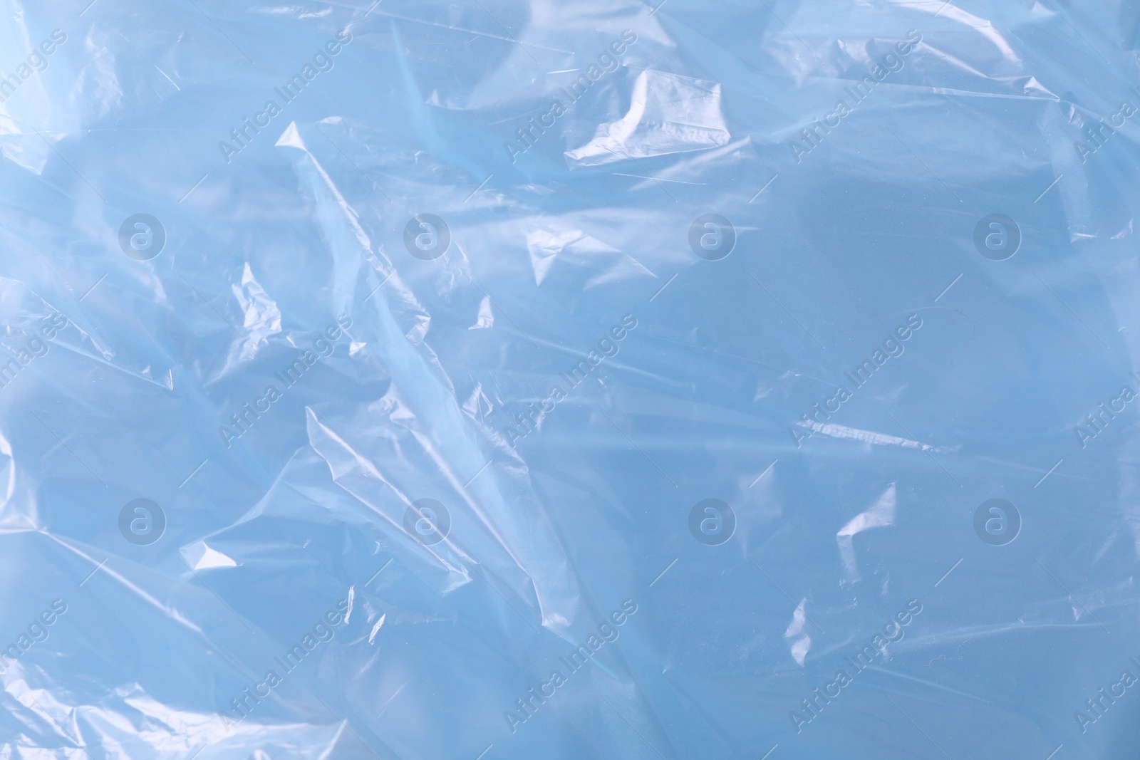 Photo of Texture of light blue plastic bag as background, closeup