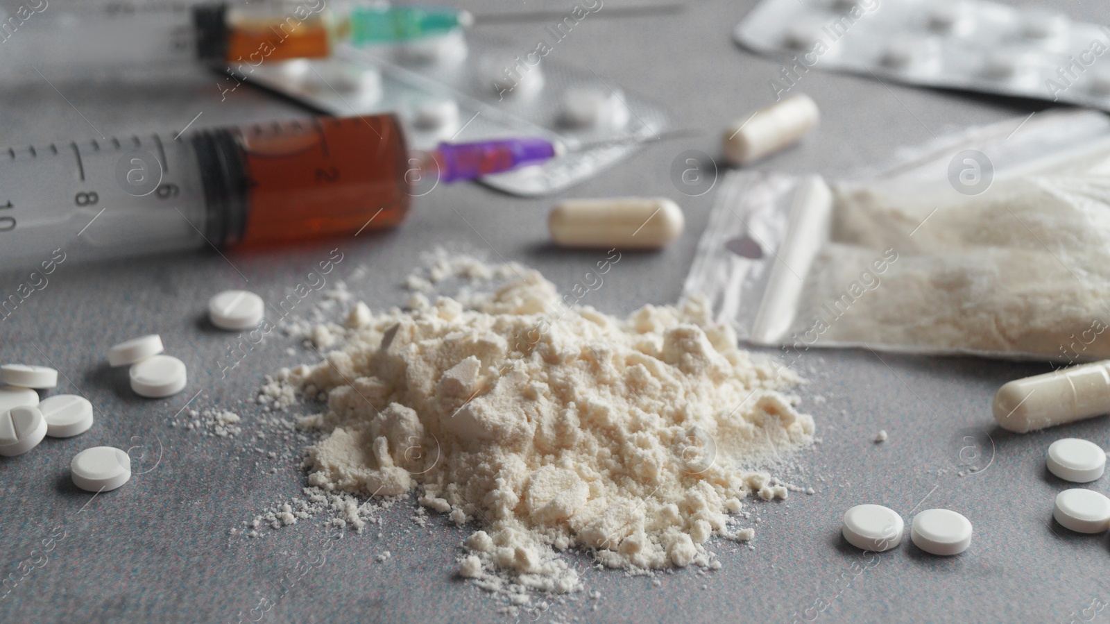 Photo of Different hard drugs on light grey table, closeup