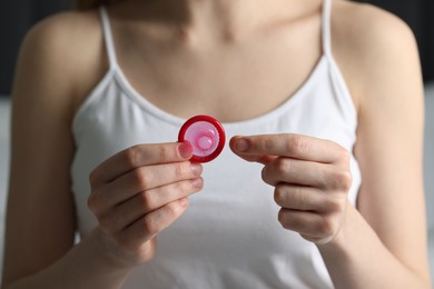 Woman holding unpacked condom, closeup. Safe sex