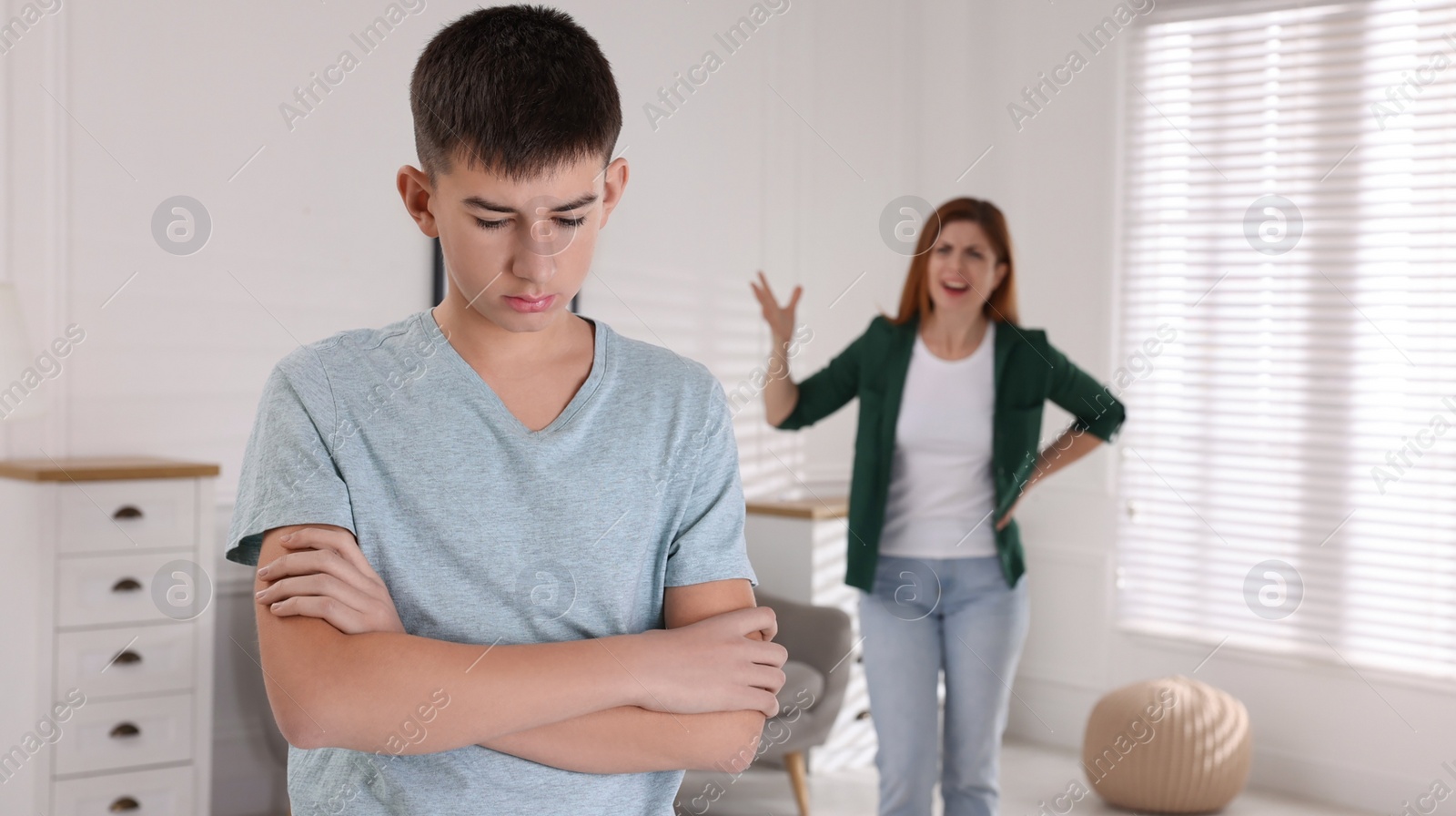 Photo of Mother scolding his son at home. Teenager problems