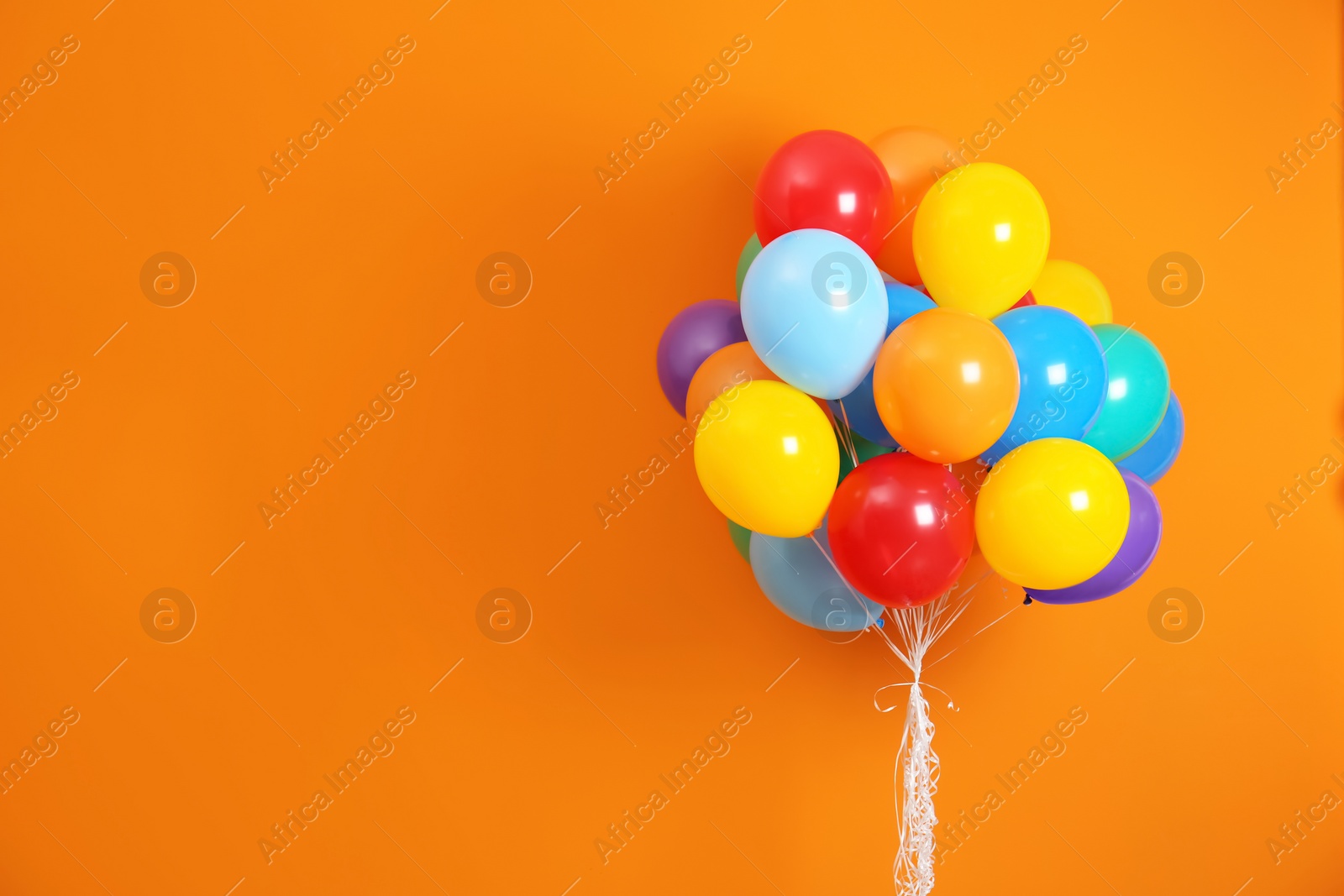 Photo of Bunch of bright balloons and space for text against color background