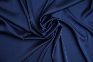 Photo of Crumpled dark blue silk fabric as background, top view