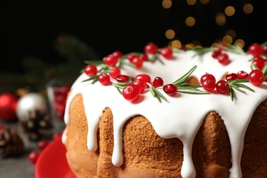 Photo of Traditional Christmas cake decorated with glaze, pomegranate seeds, cranberries and rosemary, closeup. Space for text