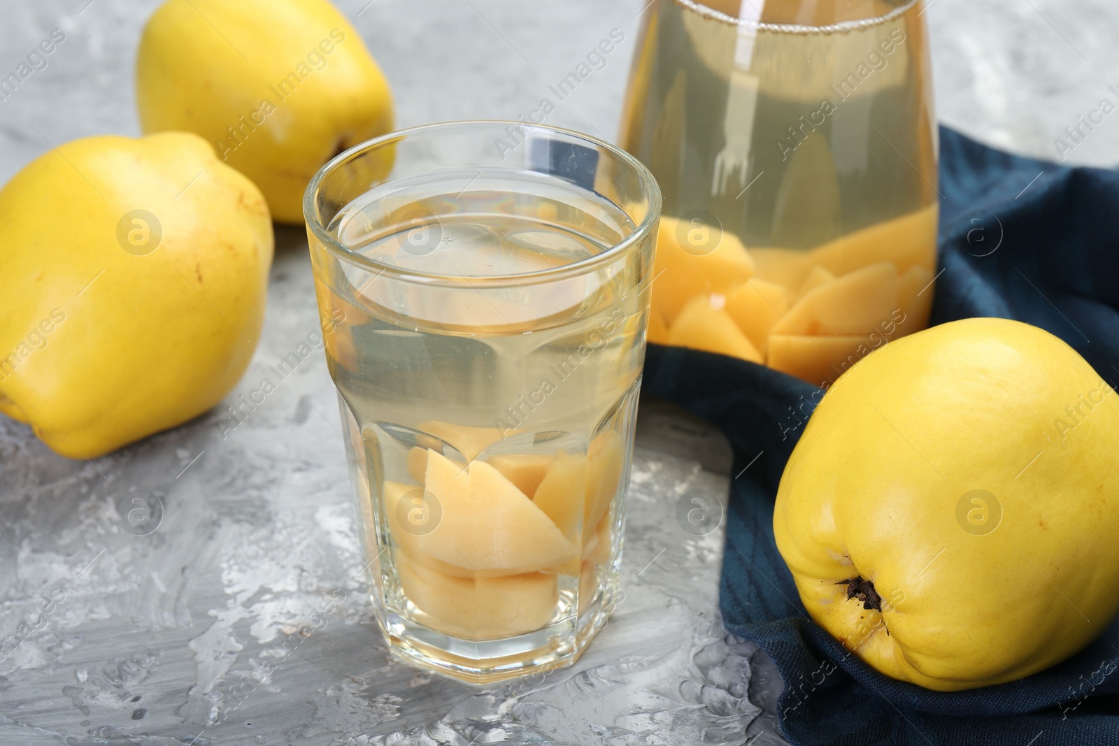 Photo of Delicious quince drink and fresh fruits on grey table, closeup