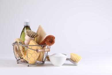 Set of different cleaning supplies in basket on white background