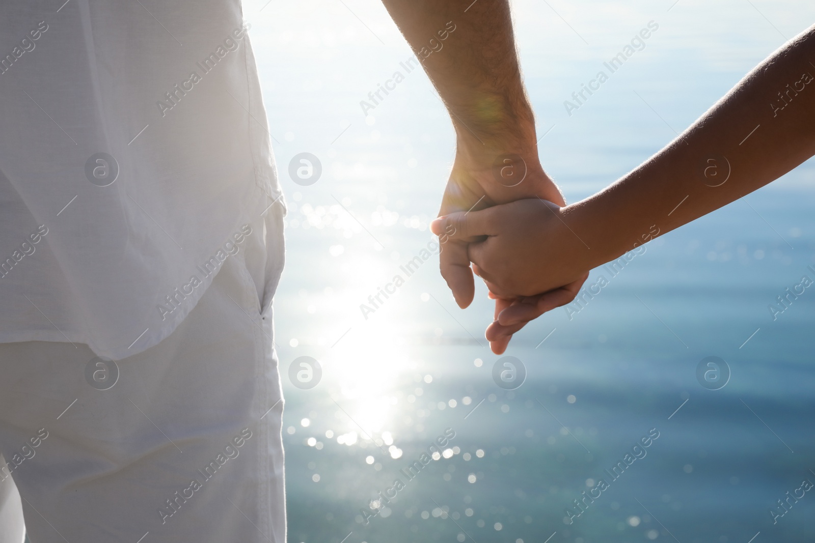 Photo of Couple holding hands together near river, closeup. Nature healing power