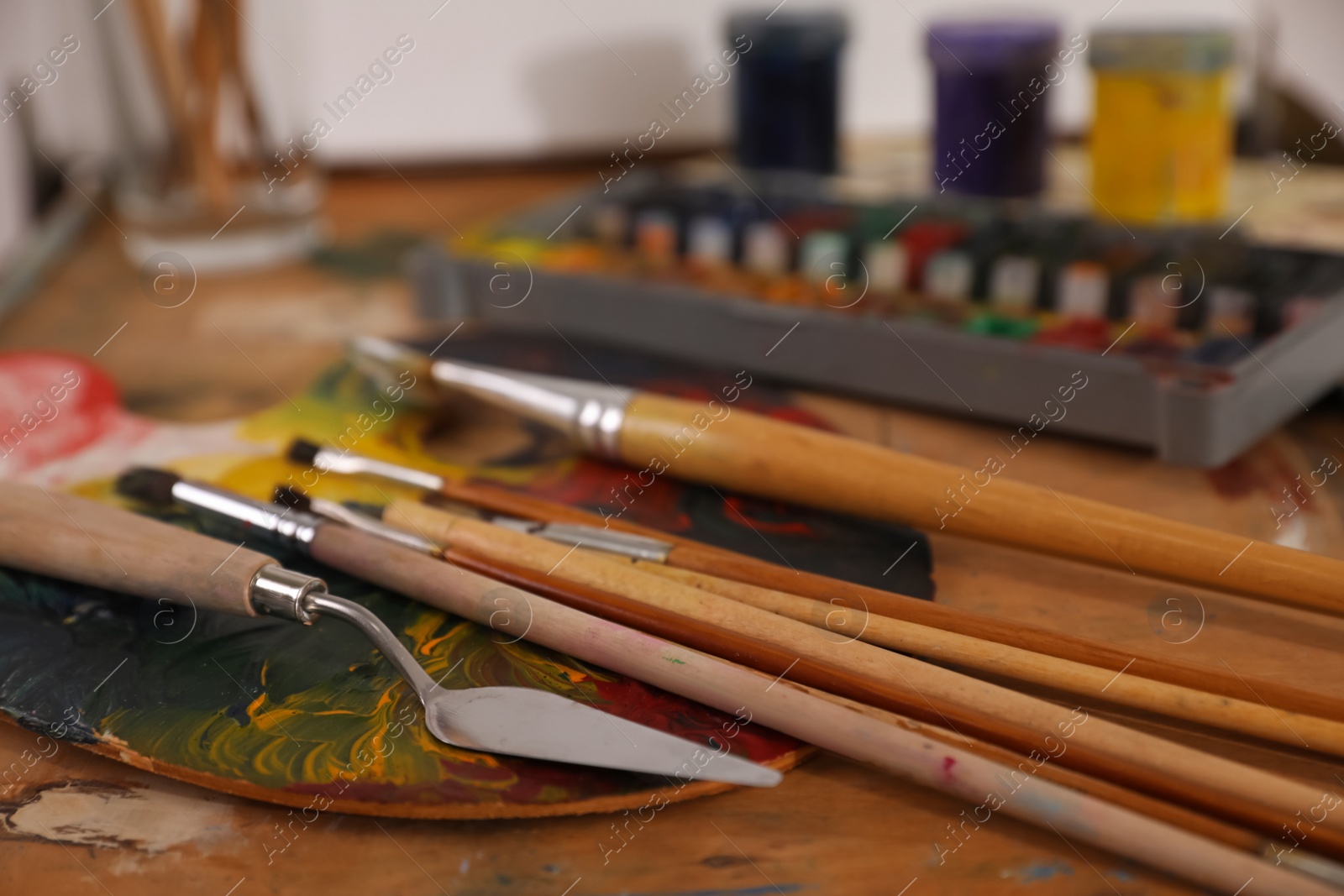 Photo of Spatula and brushes on wooden table, closeup