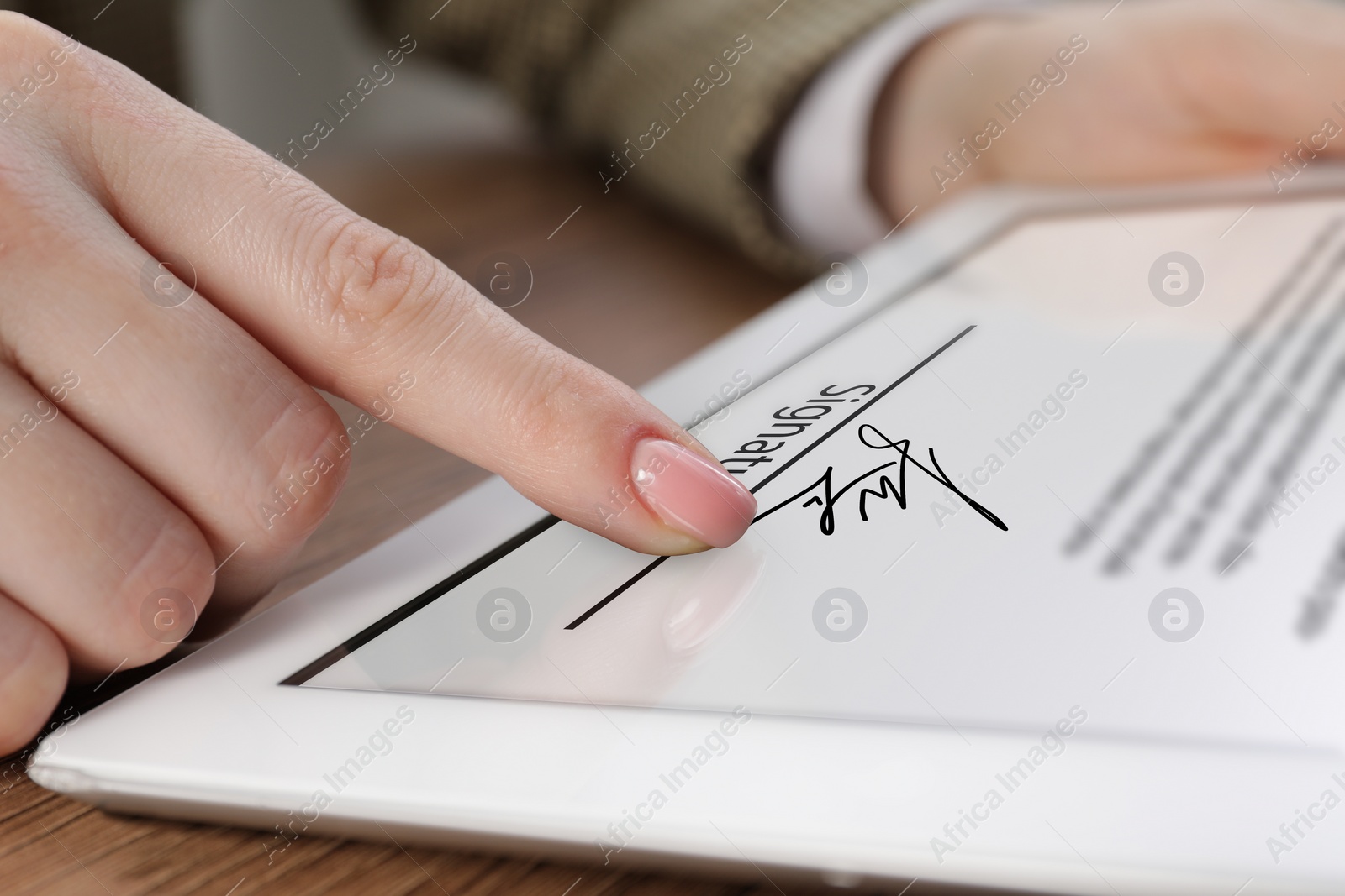 Image of Electronic signature. Woman using tablet at table, closeup