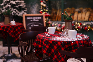 Photo of Served table in modern outdoor cafe. Christmas celebration