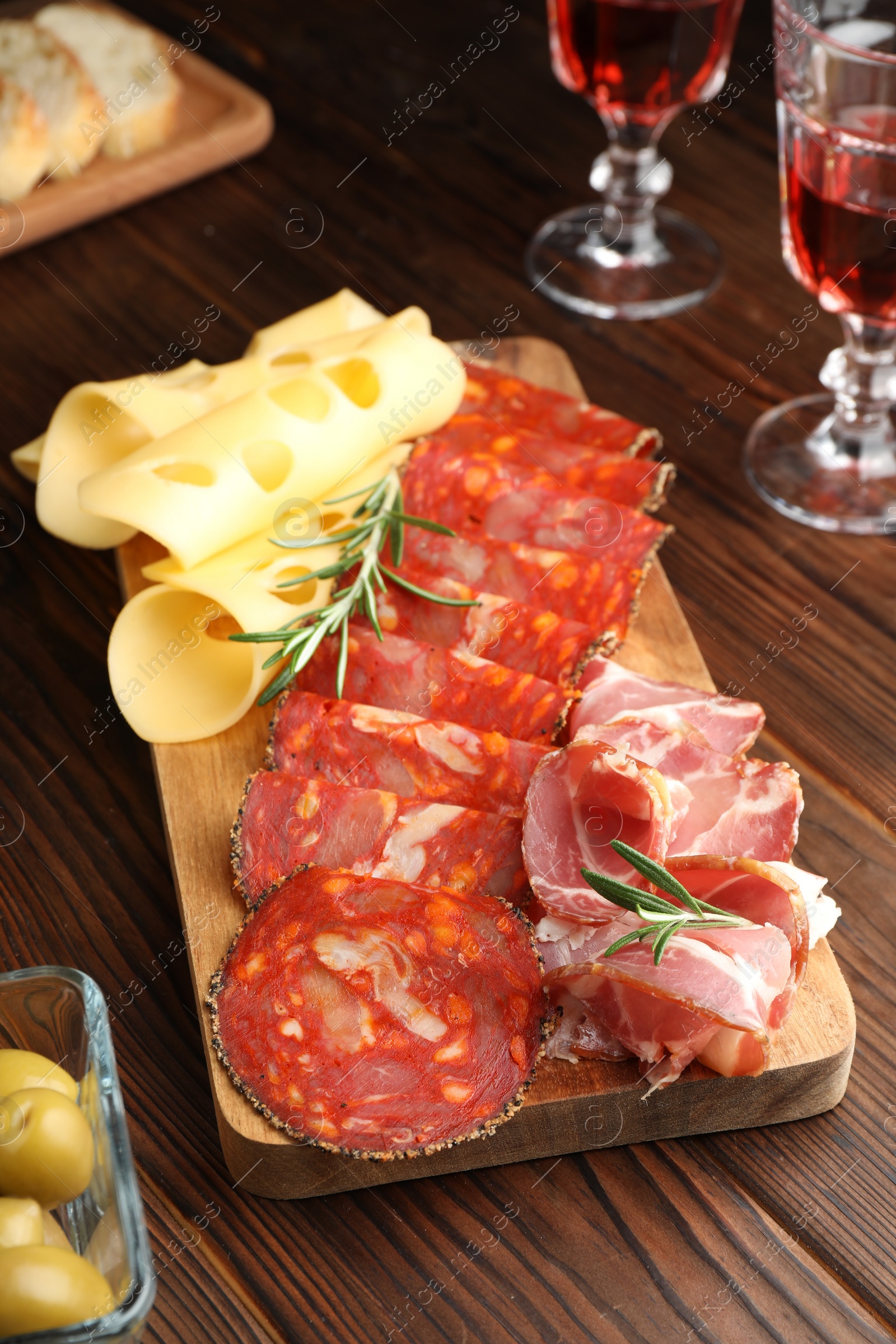 Photo of Delicious charcuterie board served on wooden table