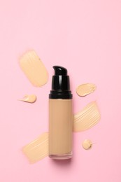 Photo of Liquid foundation and swatches on pink background, top view