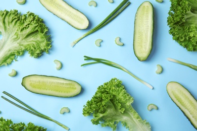 Flat lay composition with fresh ingredients for salad on light blue background