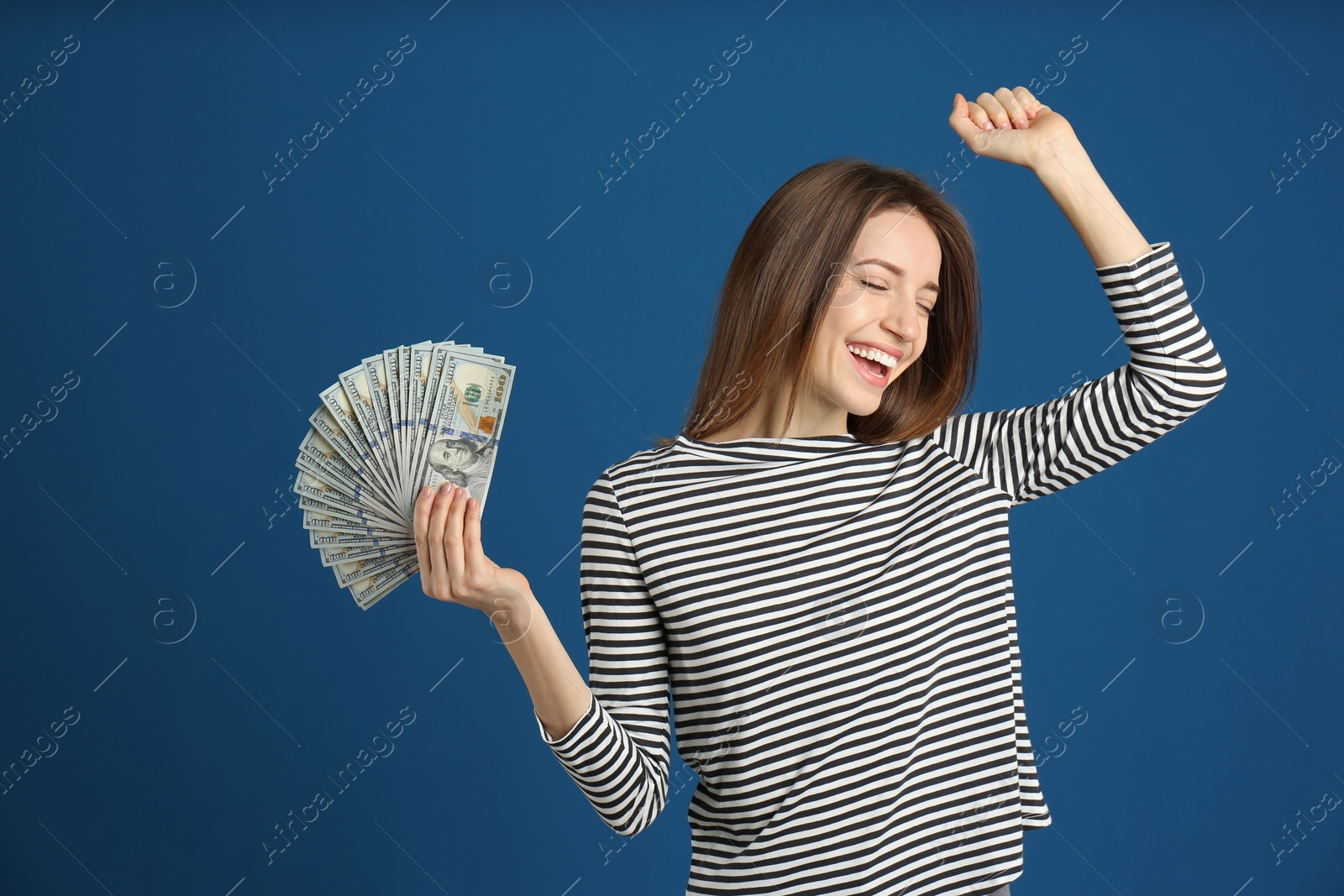 Photo of Happy young woman with cash money on blue background