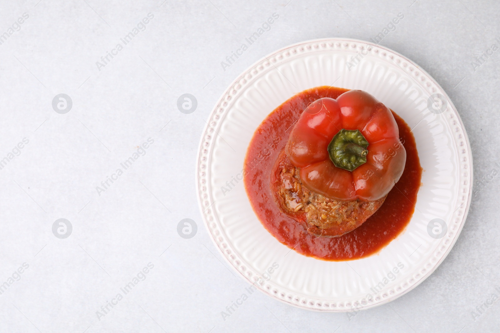 Photo of Delicious stuffed bell pepper on light table, top view. Space for text