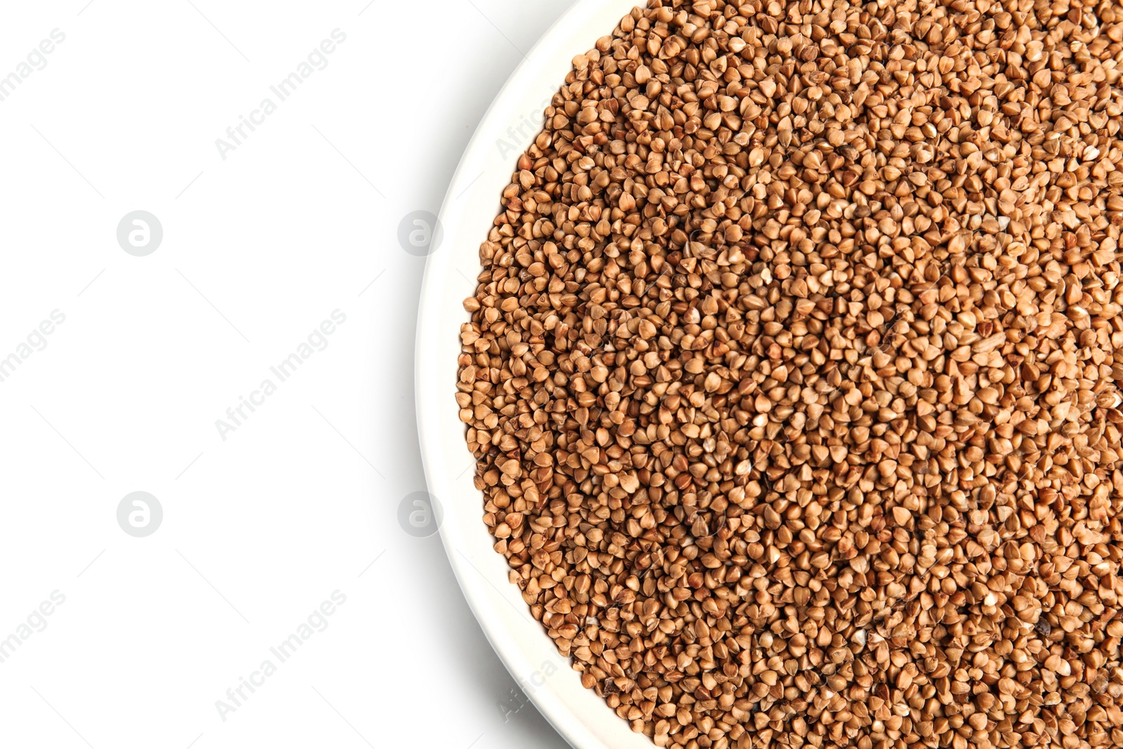 Photo of Bowl with uncooked buckwheat on white background, top view