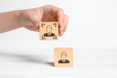 Professional buyer. Woman holding wooden cube with human icon on white background, closeup