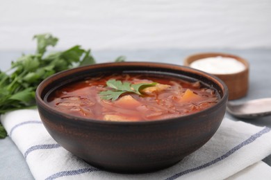 Photo of Bowl of delicious borscht on table, closeup