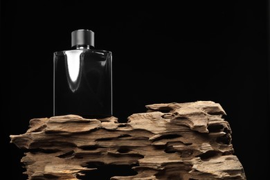 Photo of Luxury men`s perfume in bottle against black background, low angle view