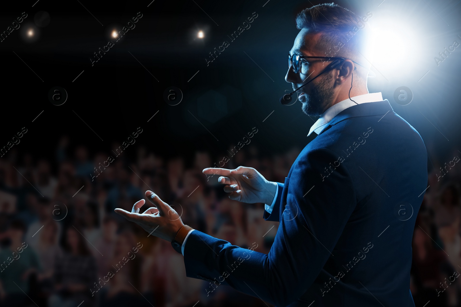 Image of Motivational speaker with headset performing on stage