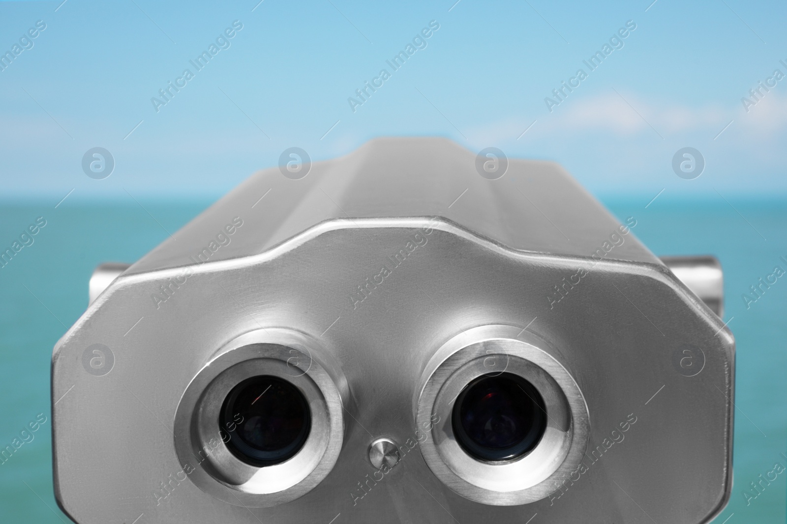 Photo of Metal tower viewer installed near sea, closeup. Mounted binoculars