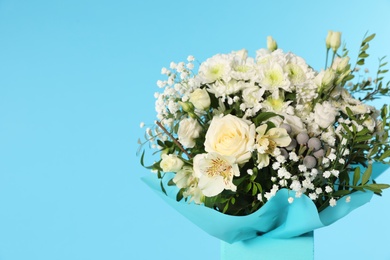 Photo of Beautiful bouquet of flowers in decorative crate on color background. Space for text