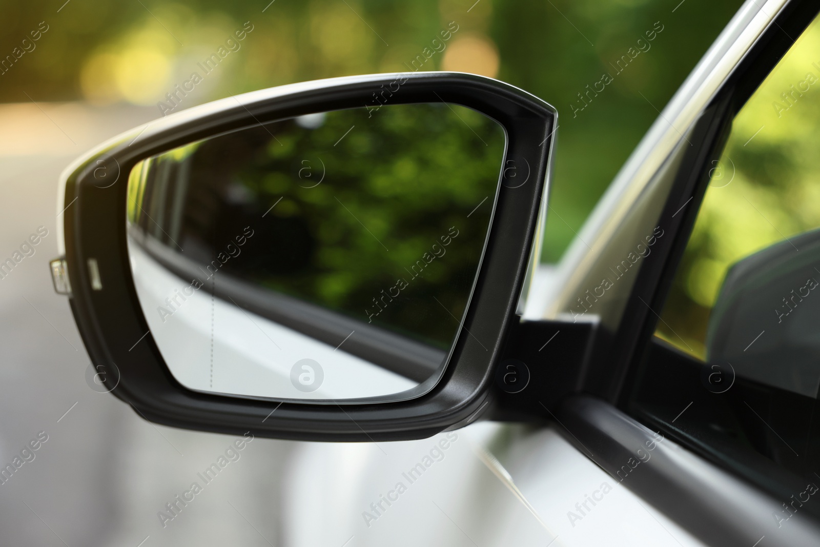 Photo of Side view mirror of modern car on blurred background, closeup