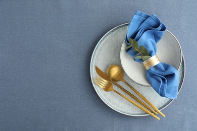 Stylish setting with cutlery, dishes, napkin and floral decor on table, top view. Space for text
