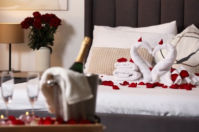 Photo of Honeymoon. Swans made with towels and beautiful rose petals on bed