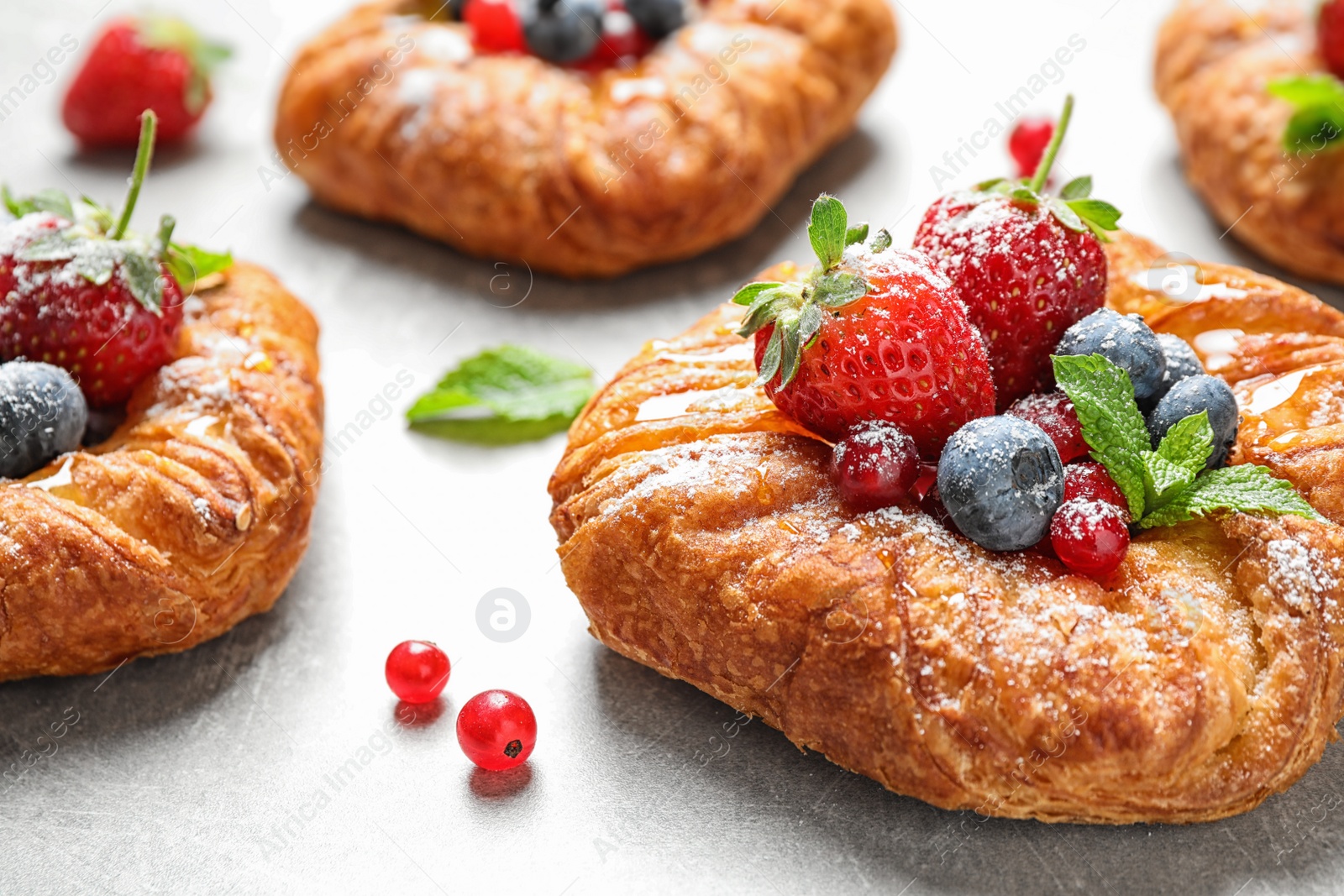 Photo of Fresh delicious puff pastry with sweet berries on light background, closeup