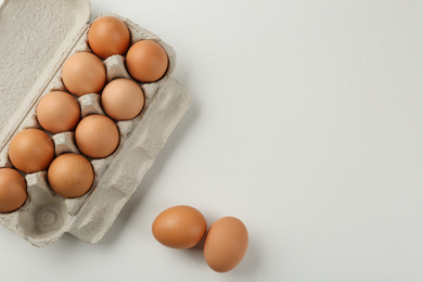 Photo of Raw chicken eggs on white table, flat lay. Space for text