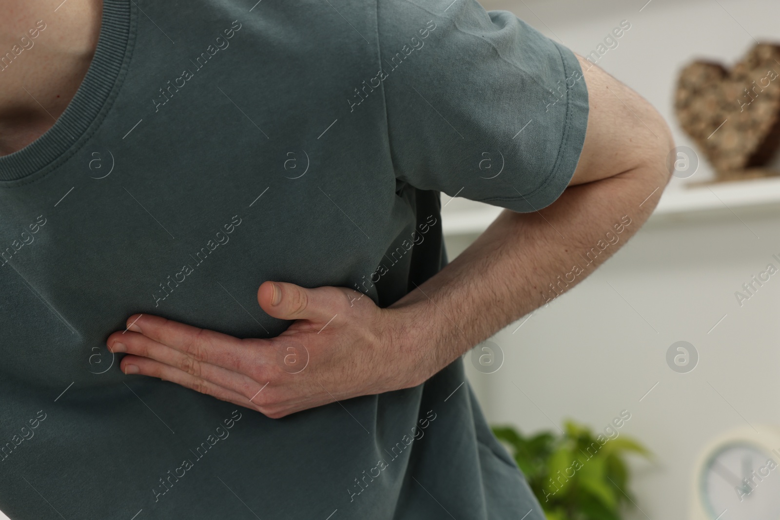 Photo of Man suffering from heart hurt at home, closeup