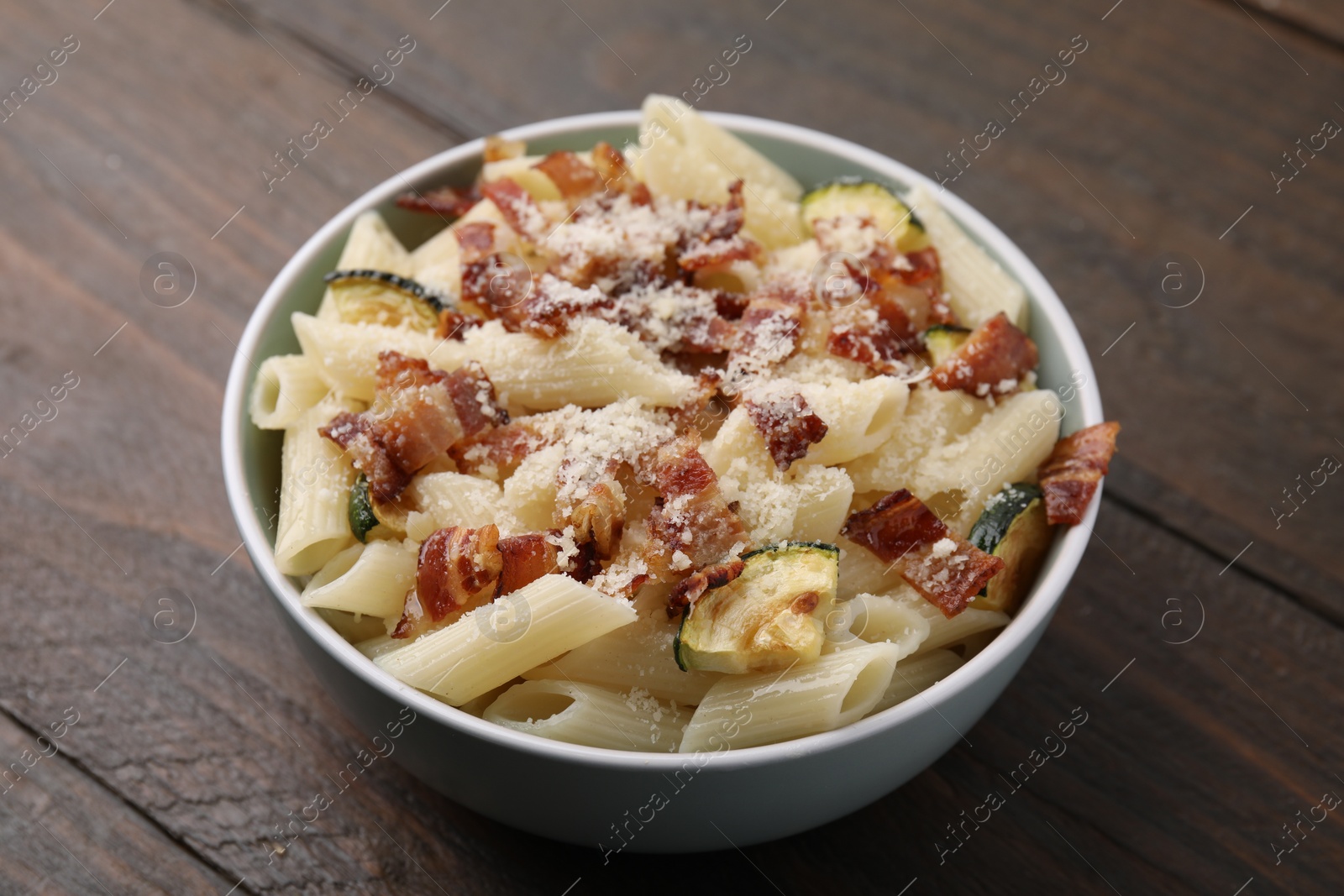 Photo of Tasty pasta with bacon and cheese on wooden table, closeup